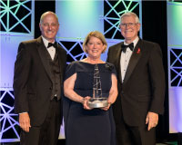 Pam Melroy (center) receiving the National Space Trophy, presented by Stephen Koerner (left) and Mike Coats (right)